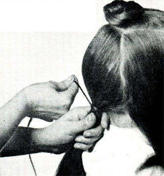 Рис. 200. Положение рук при связывании пряди длинных волос